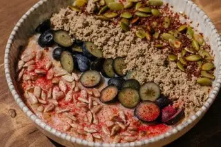 Каша из овса на миндальном молоке с халвой, семечками, голубикой и темным шоколадом