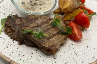 Медальоны из говяжьей вырезки с картофелем под грибным соусом